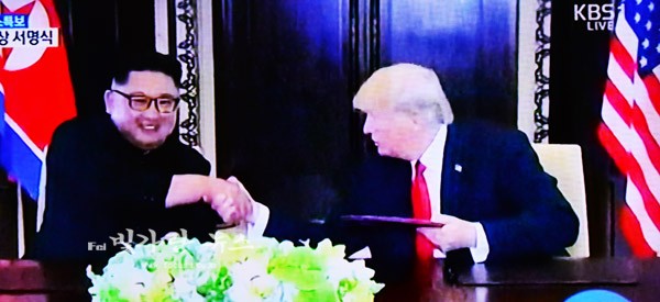 ▲ 합으문에 서명후 악수를 교환하고 있는 김정은 위원장과 트럼프 대통령 (KBS TV화면 촬영)
