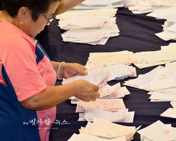 귀중한 주권을 행사한 시민의 투표용지를 후보별로 선별하고 있는 개표요원