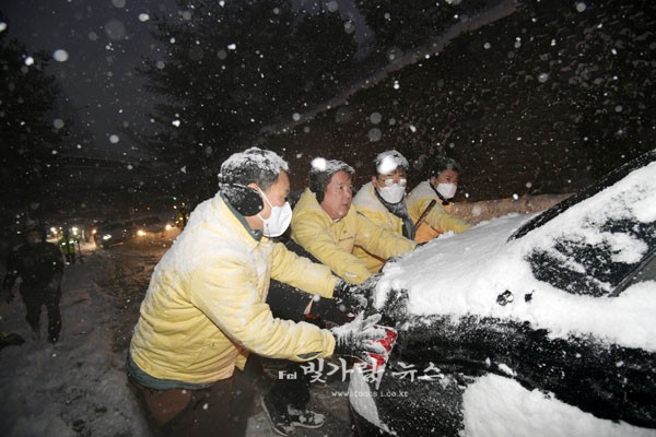 ▲ 빙판길 미끄러지는 차량을 돕고 있는 김병내 청ㅊ장과 직원